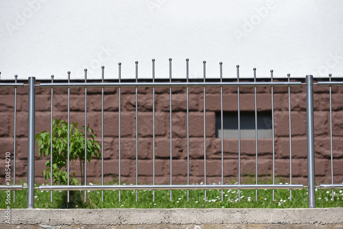 Small iron and transparent fence on the background of a residential building in a European city