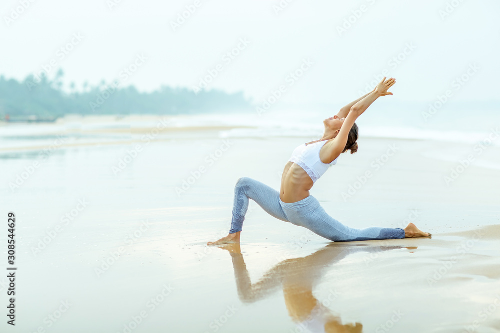 Caucasian woman practicing yoga at seashore Caucasian woman practicing yoga at seashore