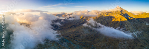 Aerial panoramic of sea of clouds over Pizzo Tambo and bends of the Spluga Pass road, Valle Spluga, Valtellina, Lombardy photo