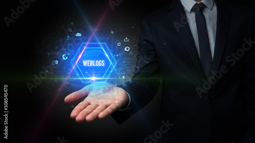 Wallpaper Mural Man hand holding WEBLOGS inscription, social media concept Torontodigital.ca