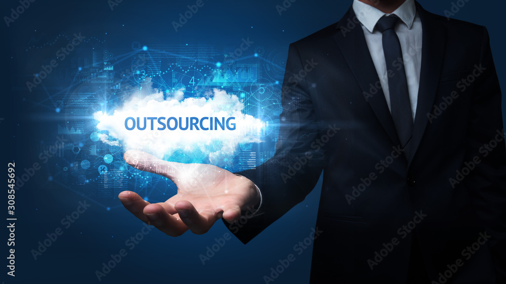 Hand of Businessman holding OUTSOURCING inscription, successful business concept Hand of Businessman holding OUTSOURCING inscription, successful business concept