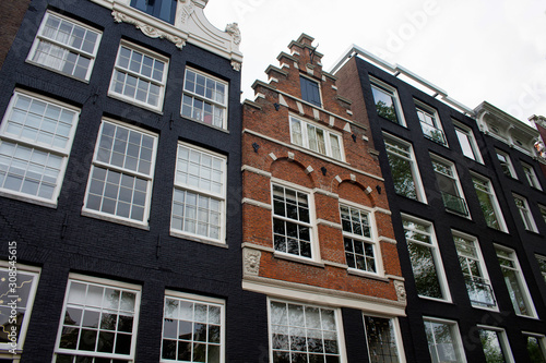 Bottom view of historical, traditional and typical building showing Dutch architectural style in Amsterdam. It is a sunny summer day.