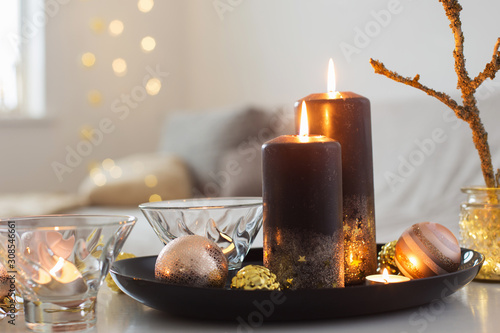 black burning candles with Christmas balls in white interior