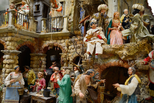 Whimsical creche scene of people in Bethlehem village including holy family and Magi