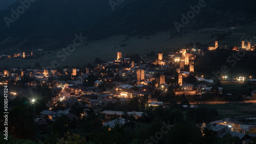 Night view on Mestia with its beautiful illuminated Svan Towers and high mountains. Svaneti, Georgia. © k_samurkas