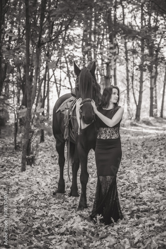 Vintage photo, elegant woman in black dress with a horse © T.Den_Team