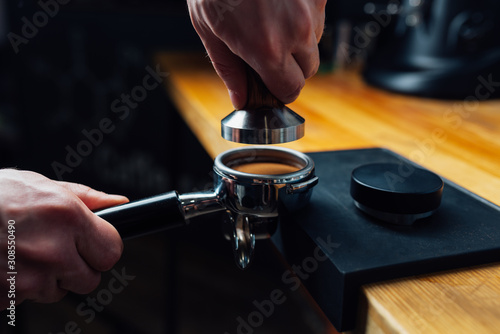tempered coffee in portafilter on a dark background photo