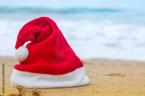 Santa hat on the sandy ocean