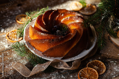 Delicious homemade freshly baked orange and lemon cake. Rustic style decor, wooden background. Christmas festive holiday mood, cozy home atmosphere. Tasty traditional dessert