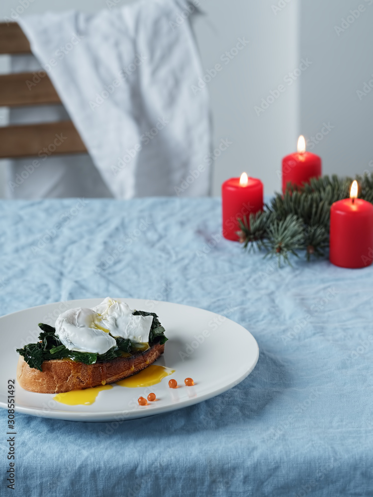 Eggs Benedict with Dutch egg and butter sauce and red caviar. Close-up. Tasty breakfast with poached eggs. Vertical orientation. Eggs Benedict with Dutch egg and butter sauce and red caviar. Close-up. Tasty breakfast with poached eggs. Vertical orientation.