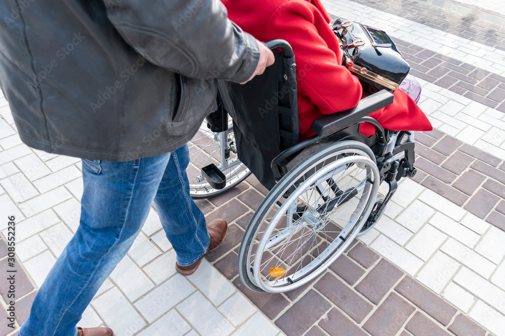 Volunteer social worker helps for disabled people and elderly people. Old woman in a wheelchair. People care about old parents. Volunteer social worker helps for disabled people and elderly people. Old woman in a wheelchair. People care about old parents.