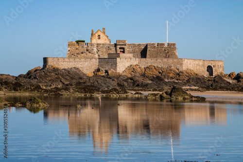 Grand Bé, a historical landmark, is a rocky island reachable by foot during low tide, with an old fort in Saint - Malo, Brittany, France. photo