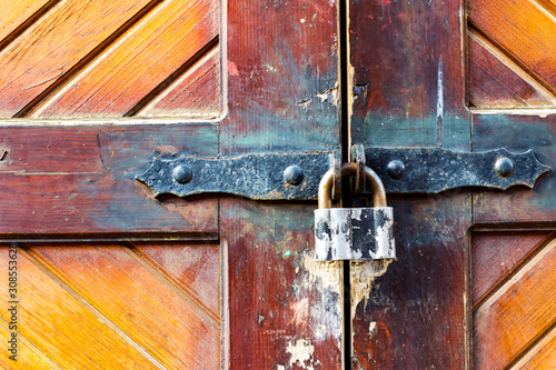 old wooden door with black metal deadbolt