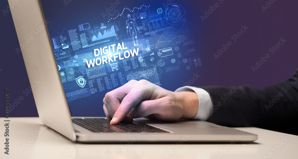 Businessman working on laptop with DIGITAL WORKFLOW inscription, cyber technology concept Businessman working on laptop with DIGITAL WORKFLOW inscription, cyber technology concept