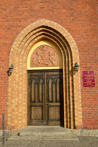 Arched portal of the main entrance. Krasnoznamensk,Kaliningrad region. Russian text - temple of the holy first-hand apostles Peter and Paul