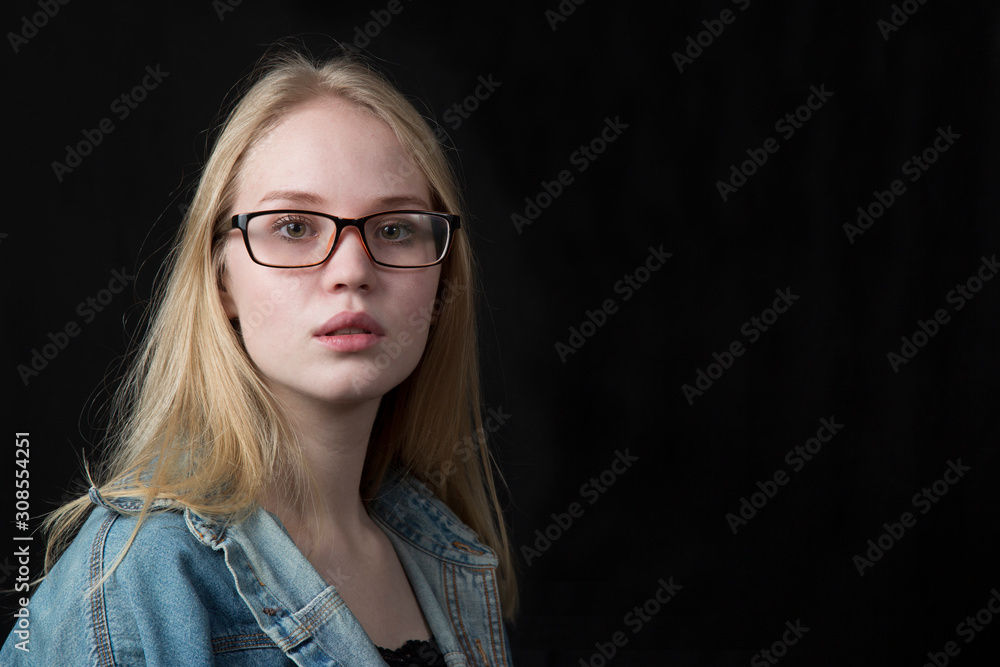 Portrait of a beautiful girl, blonde on a black background.