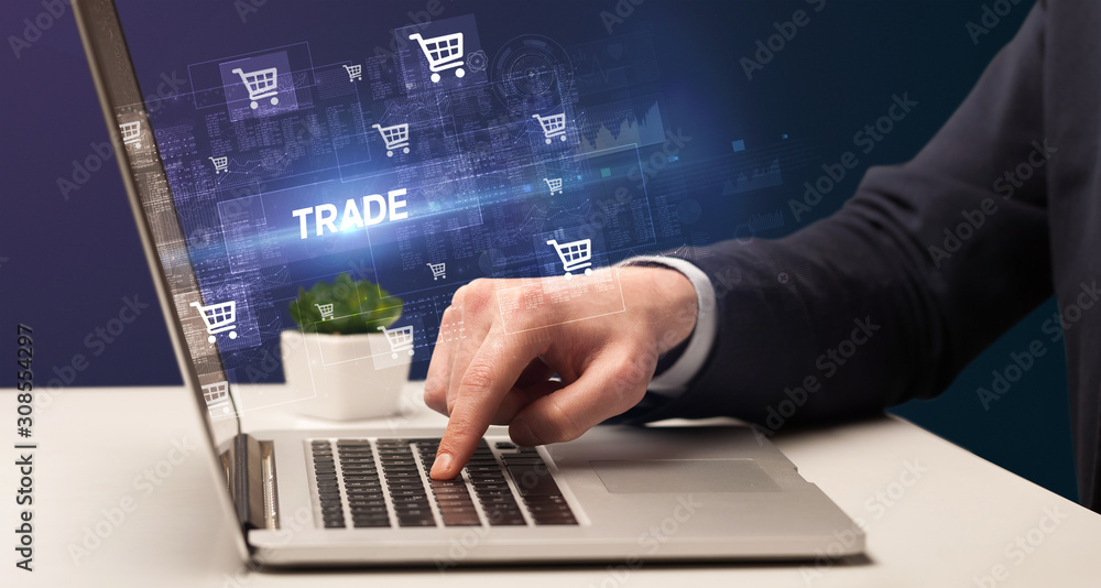Businessman working on laptop with TRADE inscription, online shopping concept Businessman working on laptop with TRADE inscription, online shopping concept