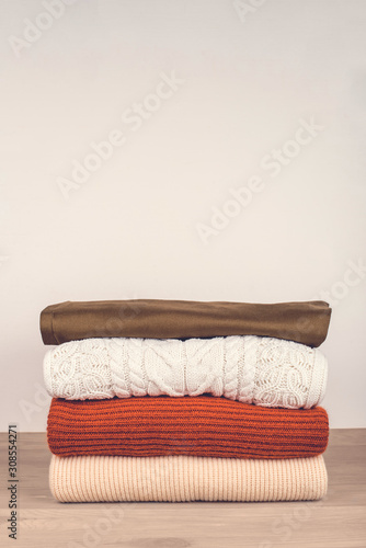 Pile of warm clothes on the table. Spring-Summer 2020 Colors. Copy space for text. © Anna