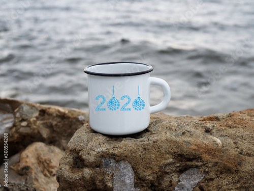 enamel white mug with coffee on a natural background of the river close-up. minimalism