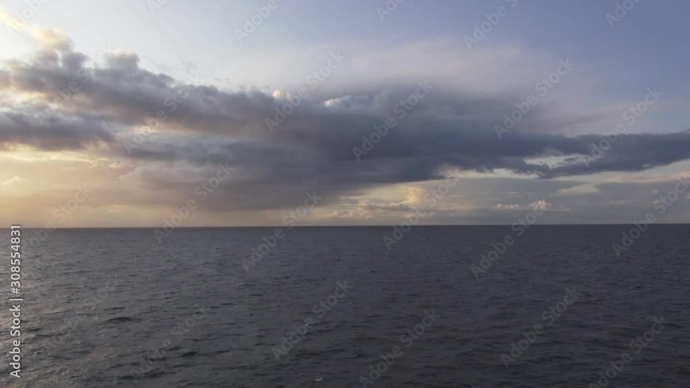 beautiful view from sailing ship deck on setting sun golden light behind clouds above rippling ocean time lapse beautiful view from sailing ship deck on setting sun golden light behind clouds above rippling ocean time lapse