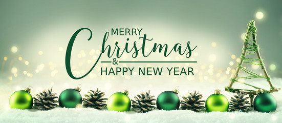Merry Christmas and Happy New Year  -  Christmas greeting card  -  Xmas tree and row of balls and pine cones in snow landscape  -  Banner, header, panorama