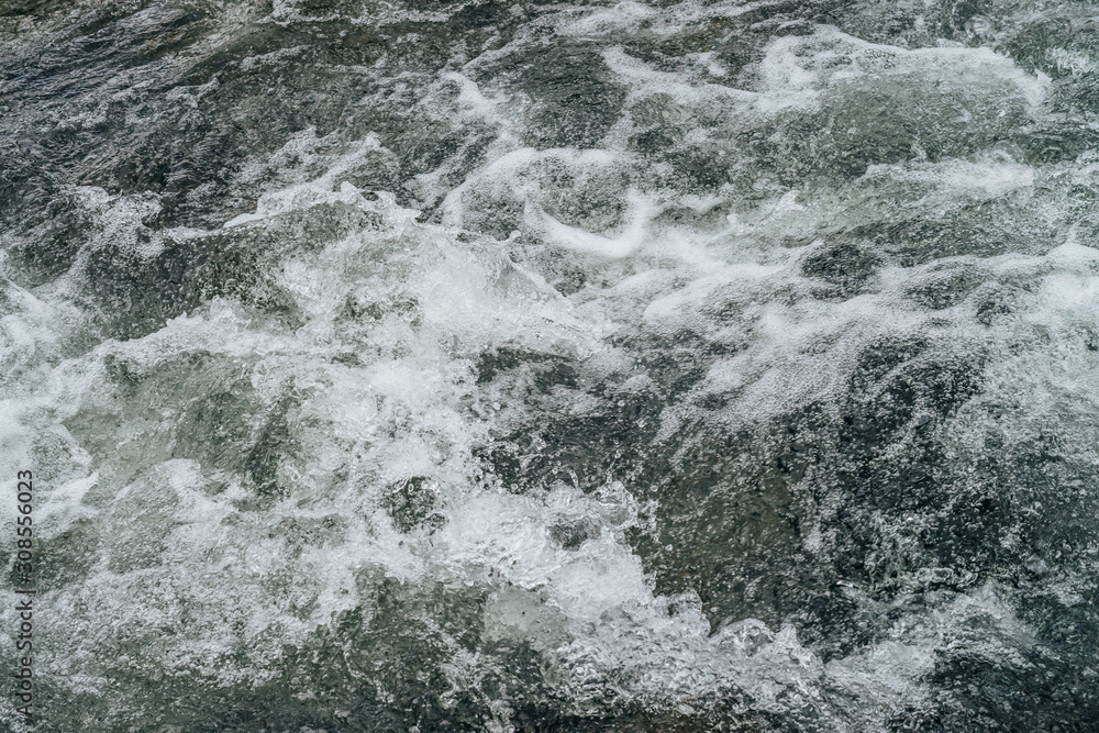 Full frame nature background of water riffle of mountain river. Powerful water stream of mountain creek with rapids. Natural textured backdrop of fast flow of mountain brook. Rapids texture close-up. Full frame nature background of water riffle of mountain river. Powerful water stream of mountain creek with rapids. Natural textured backdrop of fast flow of mountain brook. Rapids texture close-up.