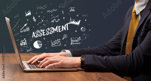 Fotografija Businessman working on laptop with ASSESSMENT inscription, modern business conce