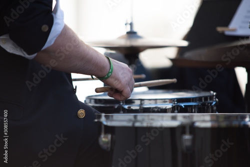 Hands of a musician playing the drums in a concert of classical music in an official act.