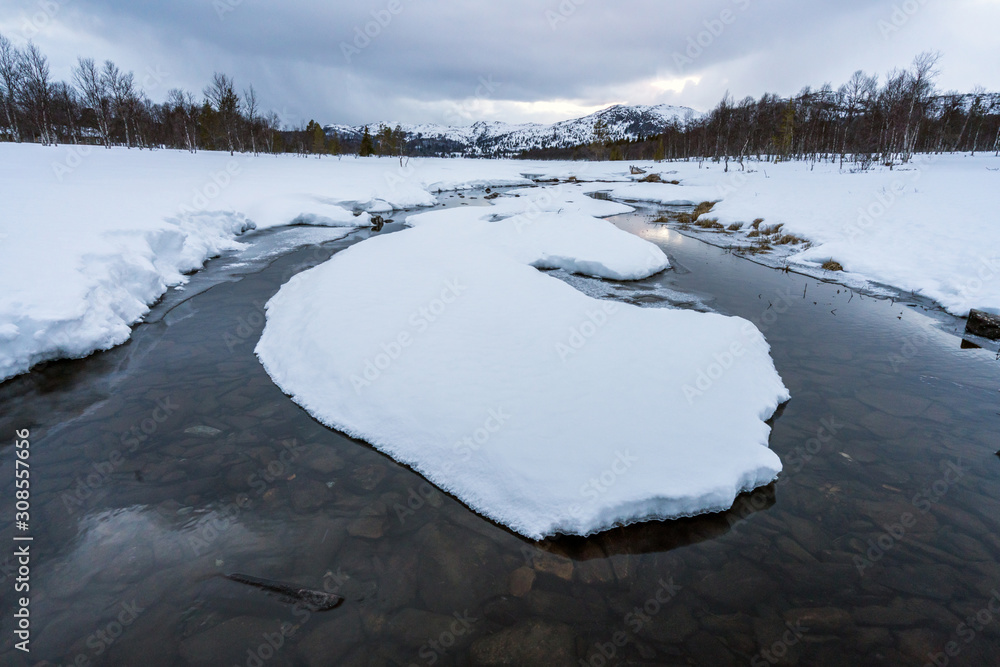 Winter landscape with snow covered lake and forest and mountains in the background. December, season and landscape concept. Winter landscape with snow covered lake and forest and mountains in the background. December, season and landscape concept.