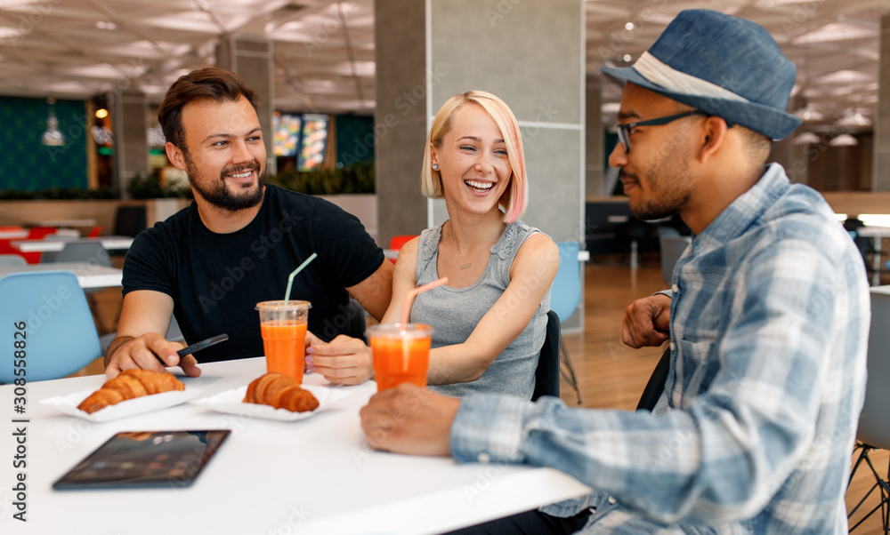 Multiethnic colleagues talking in cafe Multiethnic colleagues talking in cafe