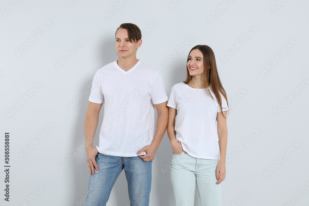 Young couple in stylish jeans on light background Young couple in stylish jeans on light background