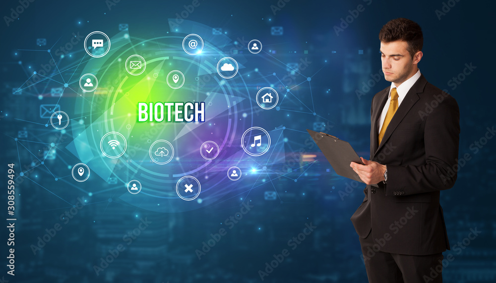 Businessman thinking in front of technology related icons and BIOTECH inscription, modern technology concept Businessman thinking in front of technology related icons and BIOTECH inscription, modern technology concept