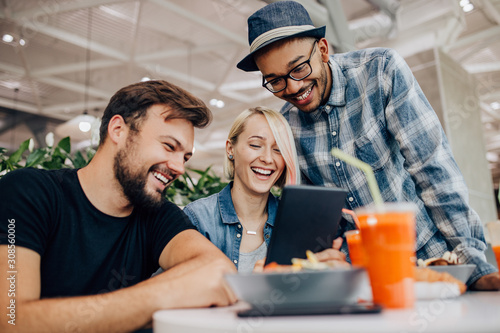 Happy diverse friends making video call in cafe