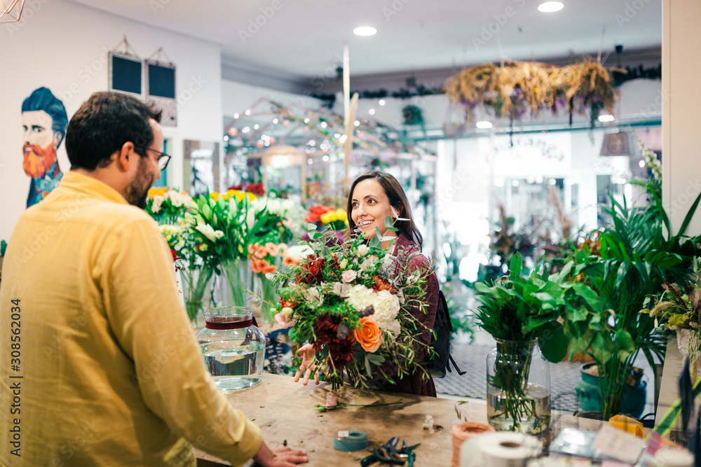 Young woman buying a bouquet of flowers in a florist