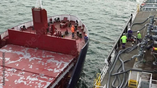 oil tanker moors to client cargo ship and experienced sailors use mooring equipment and bollards in open sea time lapse