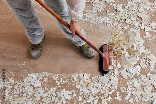 Builder sweeping the floor after renovation
