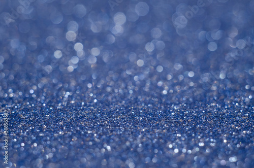 Abstract New Year blue bokeh background with shining defocus sparkles. Blurred glitters shimmering dust macro close up, copy space for text logo
