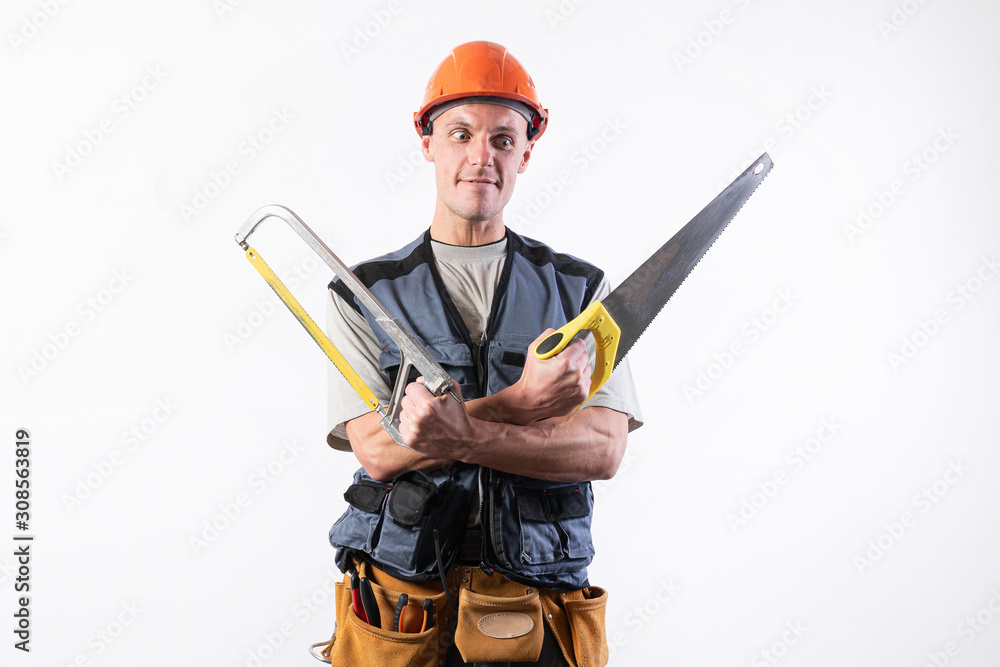 A builder with hacksaws in a helmet mocks. On a light background. A builder with hacksaws in a helmet mocks. On a light background.