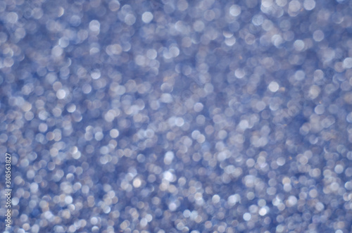 Abstract New Year blue bokeh background with shining defocus sparkles. Blurred glitters shimmering dust macro close up, copy space for text logo