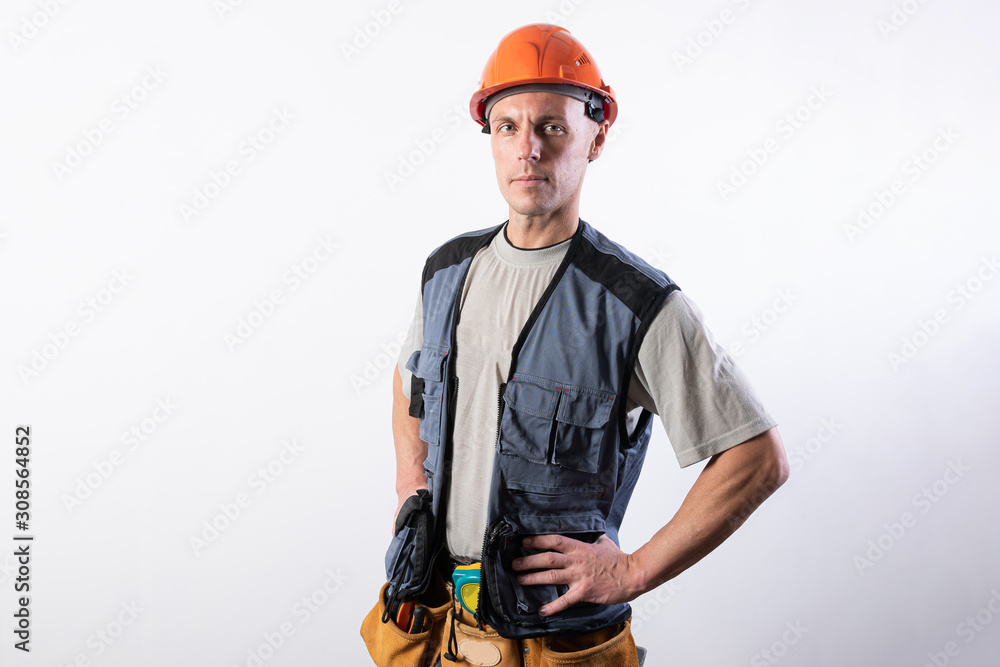 The builder put his hands on his hips. In work clothes and hard hat. The builder put his hands on his hips. In work clothes and hard hat.