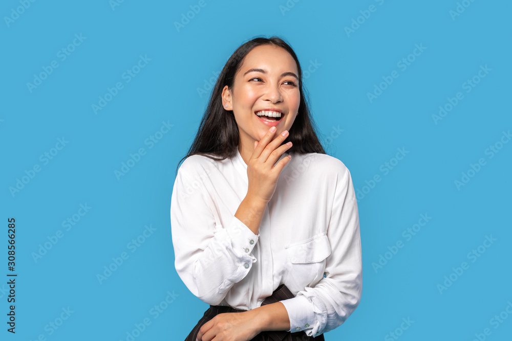 Freestyle. Young woman wearing shirt and skirt standing isolated on blue touching face laughing happy Freestyle. Young woman wearing shirt and skirt standing isolated on blue touching face laughing happy