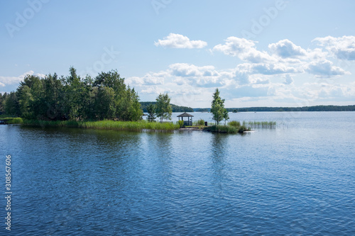 Wooden gazebo by the lake Saimaa, Finland on a beautiful sunny day. 