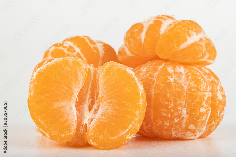 Tasty ripe mandarin on a white table. Peeled citruses. Tasty ripe mandarin on a white table. Peeled citruses.