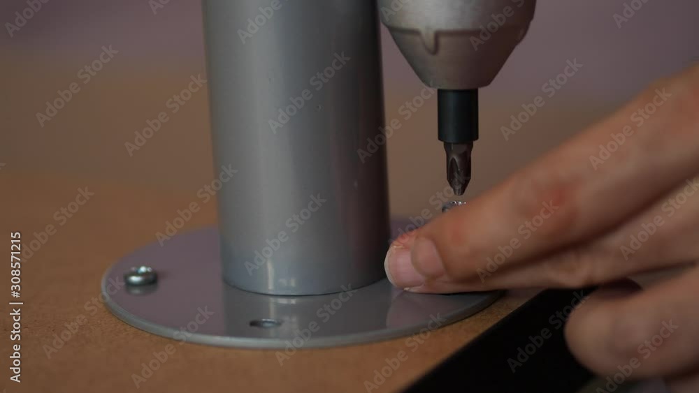 Assembling furniture, Hands of a carpenter with a electric Cordless screwdriver, tighten the screw. Assembling furniture, Hands of a carpenter with a electric Cordless screwdriver, tighten the screw.