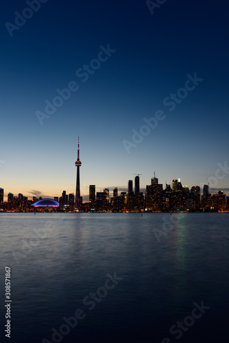 Toronto city skyline at dusk on a clear night with blue sky over Lake Ontario