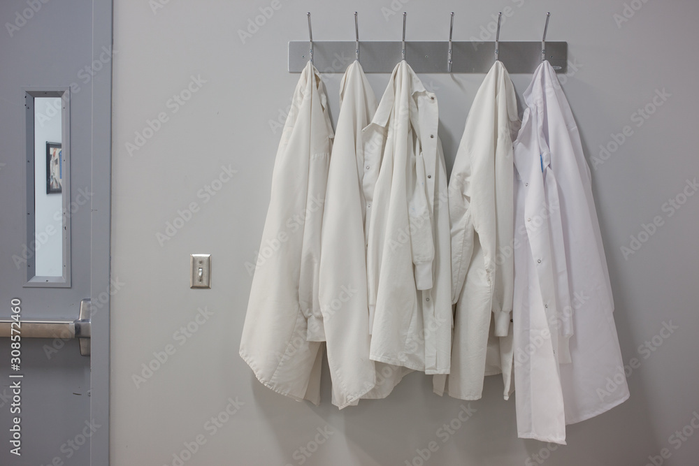 Lab coats hanging on wall at pharmaceutical laboratory Stock Photo