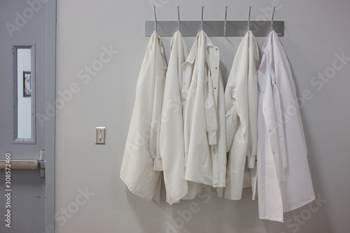 Lab coats hanging on wall at pharmaceutical laboratory