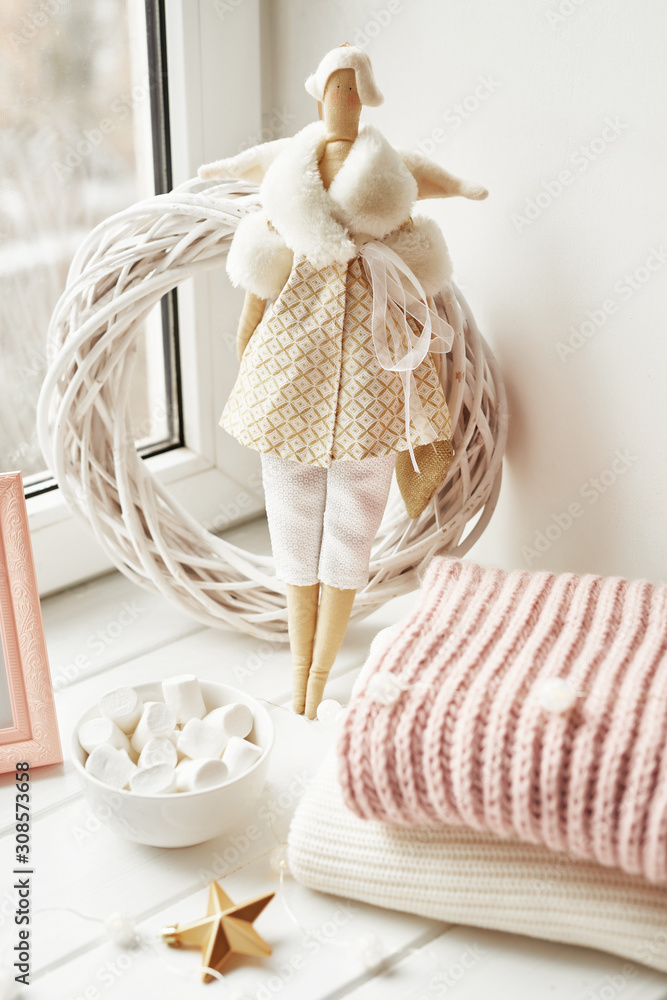 Handmade doll and marshmallows near window. Cozy winter morning. Christmas concept and mood. Postcard Template Handmade doll and marshmallows near window. Cozy winter morning. Christmas concept and mood. Postcard Template