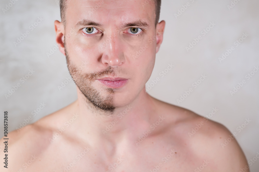 face of a man half of which is covered with stubble face of a man half of which is covered with stubble