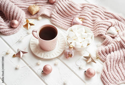 Christmas decor, balls, woolen plaid on the window background, home comfort concept, seasonal winter celebrations. Postcard Template. Christmas pink cup with marshmallow.